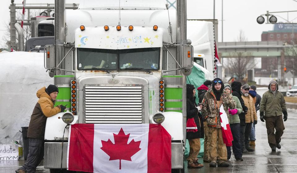 Lastbilchauffører og sympatisører på broen Ambassador, der forbinder den canadiske by Windsor med den amerikanske bilby Detroit. Nu skærper regeringen i Ontario politikken over for chaufførerne, der blokerer trafikken i protest mod coronakrav. Den canadiske provins erklæres i nødretstilstand. <i>Nathan Denette/Ritzau Scanpix</i>