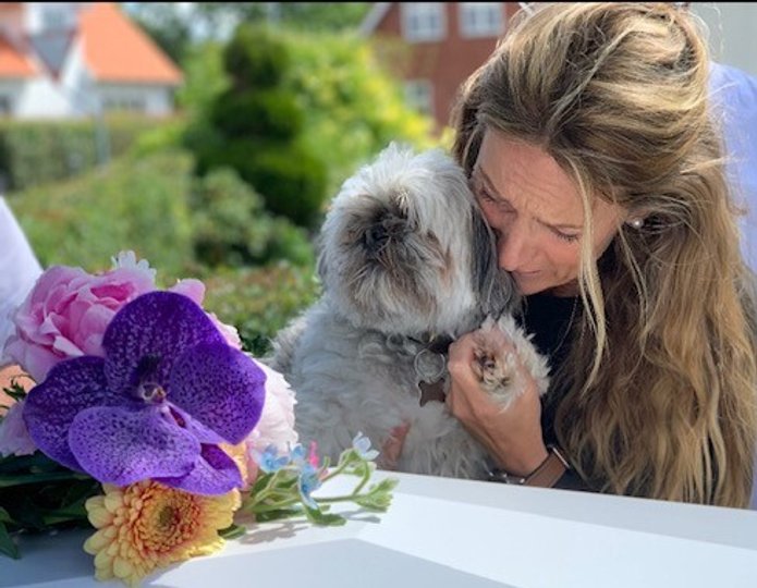 Gitte Bering krammer en af hendes og Emils to hunde, da kisten med hendes 12-årige søn blev kørt forbi deres hjem før bisættelsen. Privatfoto