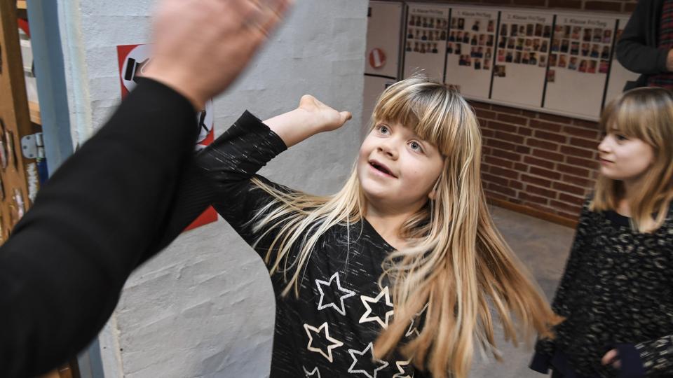 Dagen begynder med et smil - klasselæreren giver børn i Øster Hornum en morgenhilsen efter eget valg - her en "highfive". Foto: Bent Bach
