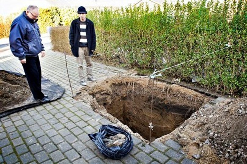 Orla Hasager (tv) og en nabo kigger på dagens fund: En død ræv, der spærrede hans kloaksystem. Foto: Peter Broen