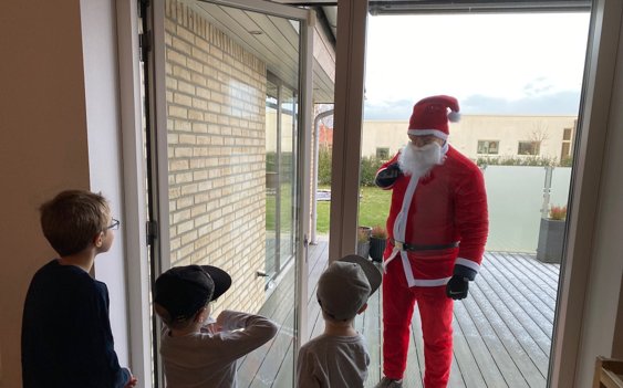 Normalt plejer William, Romeo og Sander at være ude og finde julemanden, som har gemt sig i skoven, sammen med nabobørnene, men i år måtte julemanden sige hej til de tre brødre i isolation gennem terrassedøren til hjemmet i Aabybro. Privatfoto