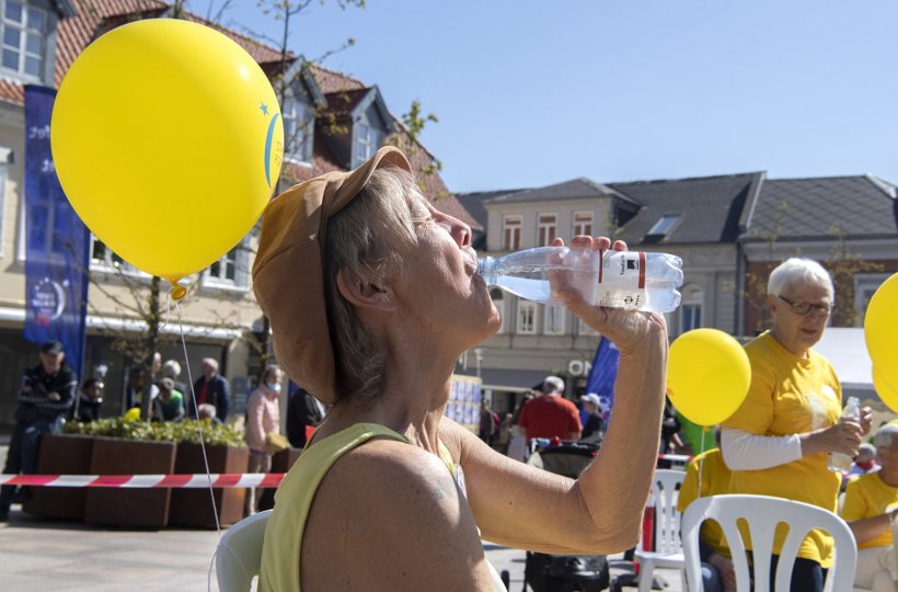"Livet er vand" står der på Pia Adelstens trøje, og hun tager selv en tår, mens de gule balloner stråler om kap med solen. Efter en march gennem gågaden slap deltagerne ballonerne løs over byen.