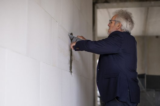 Borgmester Leon Sebbelin urutineret i gang med en murerske og en lille klat mørtel til at udjævne samlingerne i de indvendige vægge. Foto: Martél Andersen <i>Foto: Martél Andersen</i>