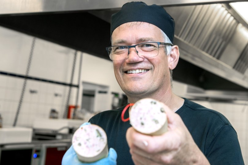 Køkkenleder Morten Mikkelsen fra Centralkøkkenet på Sødisbakke er stolt af sin kødpølse, der er med finthakket økologisk svinebryst og økologisk nakkefilet. - Jeg sætter en ære i at lave mad som i gamle dage - ikke gammeldags mad, men mad lavet fra bunden med stolthed og respekt for dem, der skal spise det, siger Morten Mikkelsen. Kødpølsen er en vigtig del af det pålægsfad, som typisk serveres til beboernes aftensmad. Foto: Henrik Louis <i>Foto:Henrik Simonsen</i>