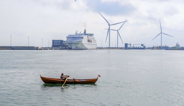 Med færgen "Norröna" i baggrunden bruger Bjarte Vestøl rå muskelkraft på at sætte kursen de sidste kilometer og åretag hjem efter to måneders rotogt rundt i det sydlige Skandinavien. Foto: Birger Josephsen