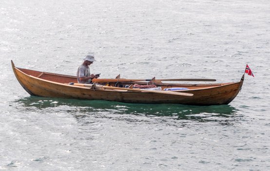 Bjarte Vestøl sidder i Hirtshals Havn med sin mobiltelefon i båden "Silje" før afgang mod Norge. Foto: Birger Josephsen
