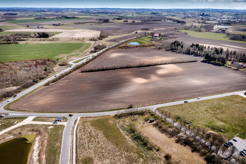 Dronen hænger her over området Højene Enge med linsen rettet mod syd - hen over Spangkærvej. Det nye boligområde vil blive placeret på de mørke marker - med Ringvejen til venstre i billedet. Foto: Torben Hansen