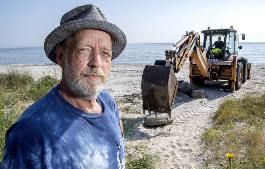 Grabben er kørt i stilling for at fjerne stenene, der i 21 år har sikret Claus Hvass’ sommerhus mod at styrte ud over kanten. Foto: Lars Pauli