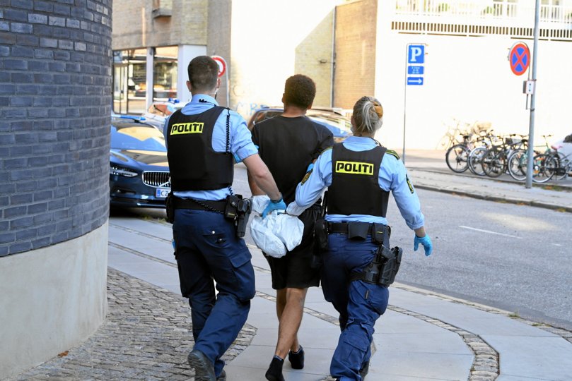 En af de sesks anholdte føres væk af betjente. Foto: Jan H. Pedersen