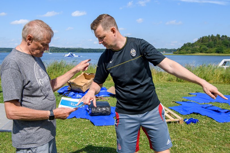Svend Skifter Andersen (tv), formand for Mariagerfjord Ungdomsskole, og Ole Aabye-Thiemer, LML Sport, arbejder på land med at puste elementer op, før de sejles ud på fjorden.