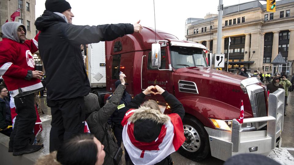 Demonstranter bakker op om en lastbil parkeret midt i den canadiske hovedstad, Ottawa. <i>Justin Tang/Ritzau Scanpix</i>