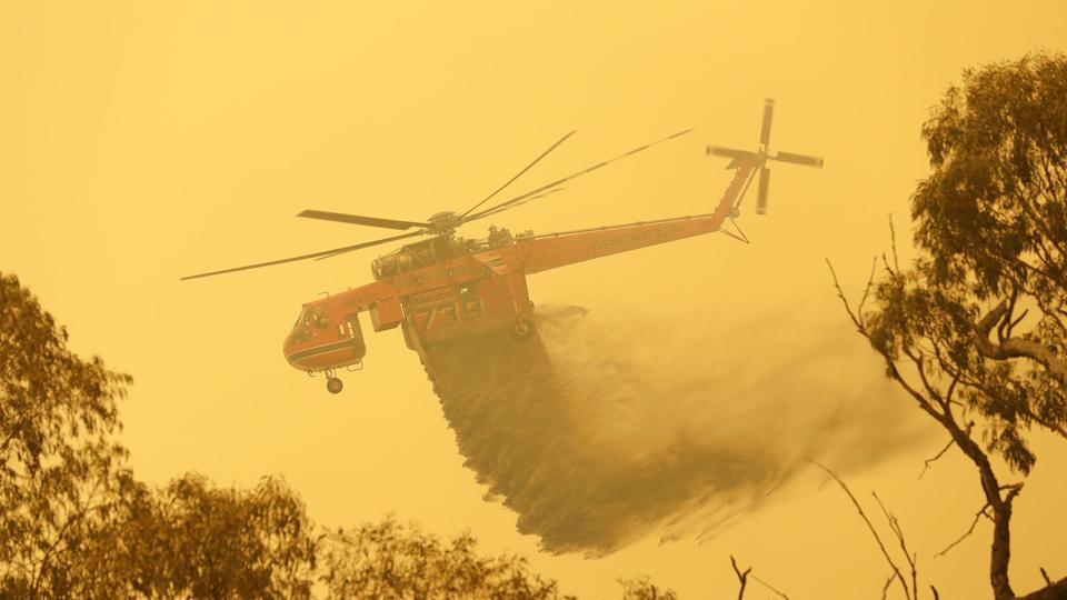 En helikopter kaster vand ned over en naturbrand i det sydøstlige Australien, 1. februar 2020. Antallet af store naturbrande vil stige kraftigt i de kommende årtier som følge af den globale opvarmning, og verdens regeringer må være langt bedre forberedt på den død og ødelæggelse, som vil blive forvoldt af brandene. Sådan lyder advarslerne i en ny FN-rapport. <i>Rick Rycroft/Ritzau Scanpix</i>
