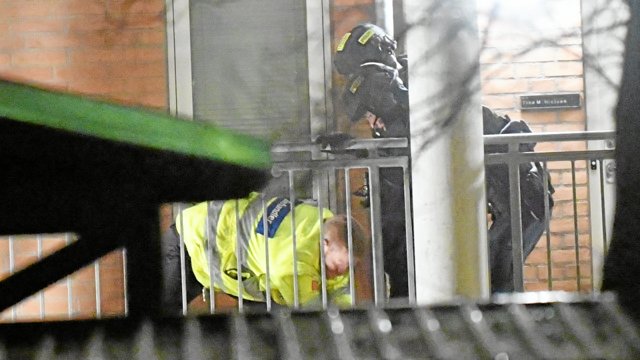 En læge tilser den sårede mand på svalegangen ved lejligheden i ejendommen Dannebrogsgade 18. Foto: Jan Pedersen