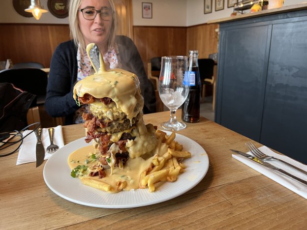Den enorme burger overhældes ved serveringen med massive mængder af ostesauce. Foto: Alberte Nilsson