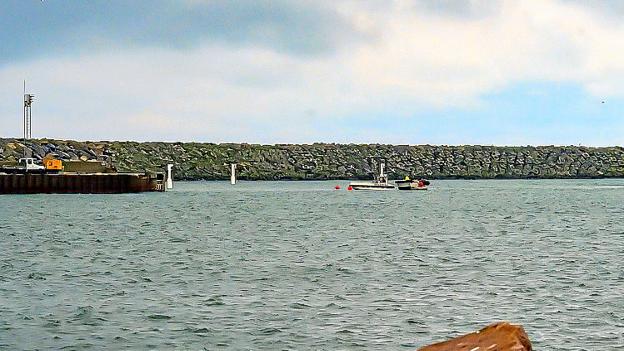 Dykkerfirmaet Rune Staal i færd med at afmærke havaristedet ud for den gamle ydermole. I baggrunden havnens nye, vestlige ydermole. Kutteren vil blive hævet på et senere tidspunkt. Foto: Ole Iversen