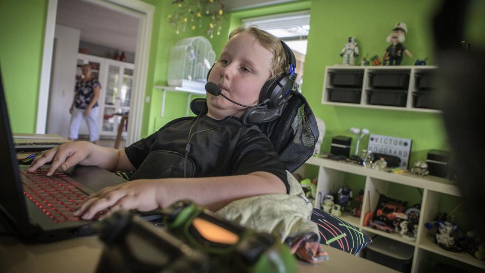 Ni-årige Victor Giliamsen fra Terndrup i Nordjylland lider af muskelsvind, som er en fremadskridende og invaliderende sygdom. Han sidder selv og spiller computer, og skal have hjælp af sine forældre til at få puder under armene.