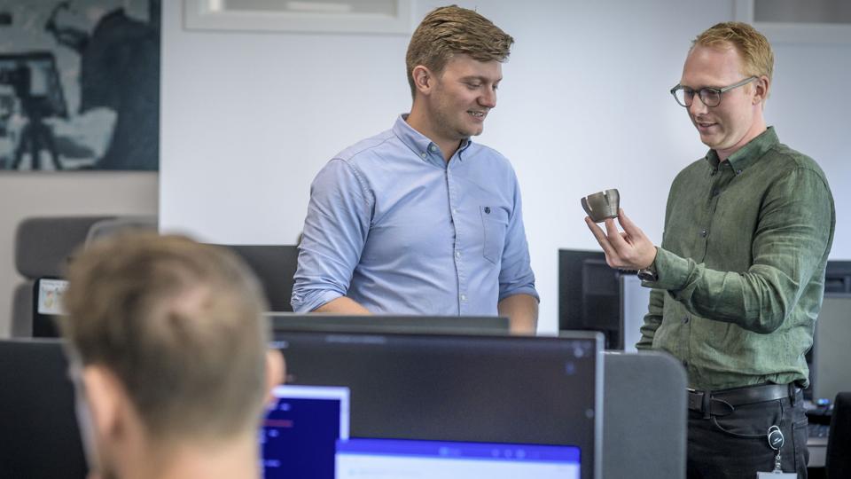 Mads Grundahl og Benjamin Juul Abildgaard, lederteam i Dansk IngeniørService, på kontoret med et blik på et beskyttelsescover i 3D-print til en 3D-mus. Foto: Martin Damgård