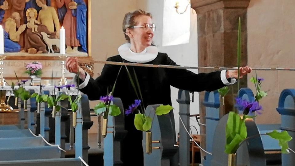 Anne Marie Nande Kraft var bevæbnet med tommestok før dagens gudstjeneste. Skjoldborg Kirke var forårspyntet med blomster og bøgeblade. Foto: Carsten Tolbøll
