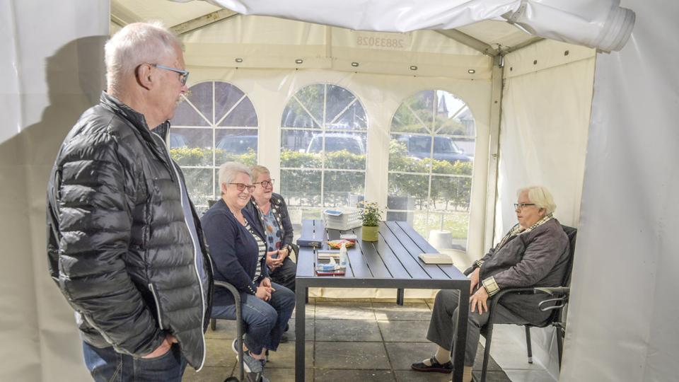 Glæden er stor på begge sider af bordet, når Lisbeth Graven og Hanne Aagaard besøger deres 92-årige mor Gunild i besøgsteltet ved Plejecentret Støberiet i Brønderslev. Da der kun må være tre i teltet, må Hannes Aagaards mand Frede Aagaard stå udenfor. Foto: Henrik Louis