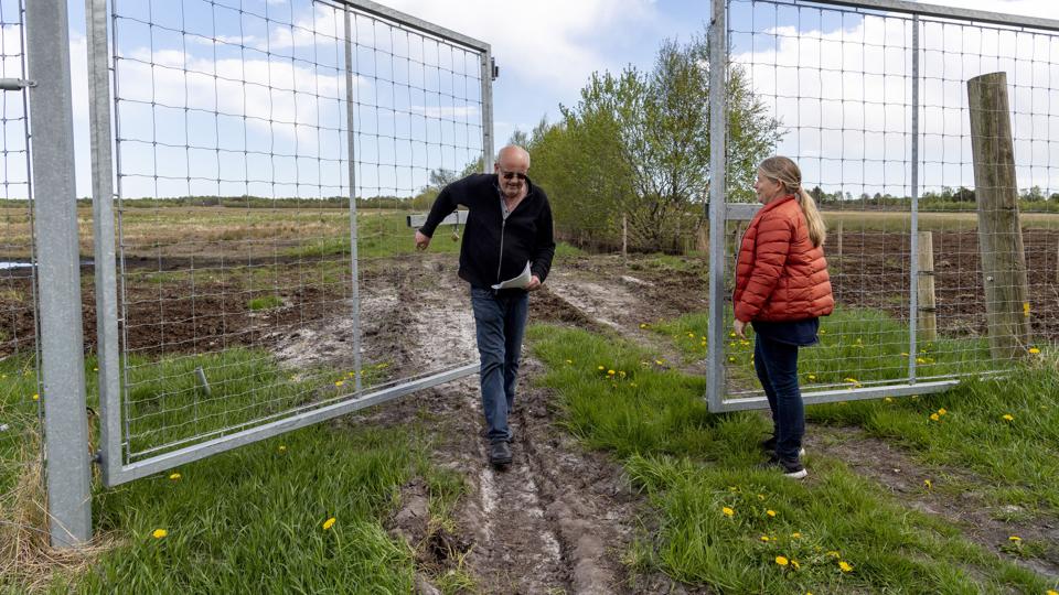 Der er solidt hegn ind til det fredede område, hvor man bl.a. kan møde elge. Men jorden bag hegnet tilhører stadig lodsejerne. Preben Clausen (tv) og Hanne Houmann Jensen lukker lågerne efter sig. Foto: Kim Dahl Hansen <i>Kim Dahl Hansen</i>