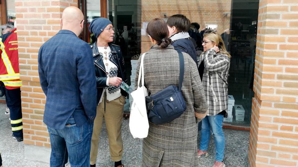Helle Lynggaard med blå hovedbeklædning diskuterer situationen med sine ansatte foran bagindgangen til Nif-Nif. Foto: Bo Lehm