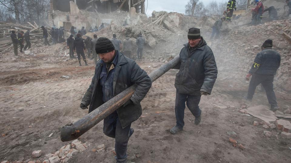Folk er her ved at fjerne vragrester efter et luftangreb nær byen Sumy i det nordøstlige Ukraine. <i>Press Service Of The Ukrainian G/Reuters</i>