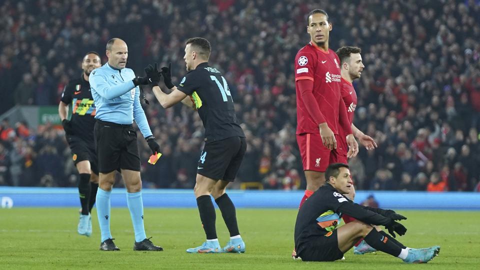 Alexis Sánchez sidder på Anfields græstæppe, efter at han har modtaget sit andet gule kort i kampen mod Liverpool. <i>Jon Super/Ritzau Scanpix</i>