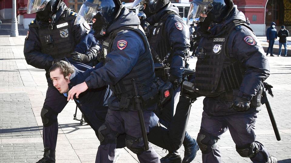 Kampklædt politi slæber afsted med en demonstrant i det centrale Moskva søndag. <i>-/Ritzau Scanpix</i>