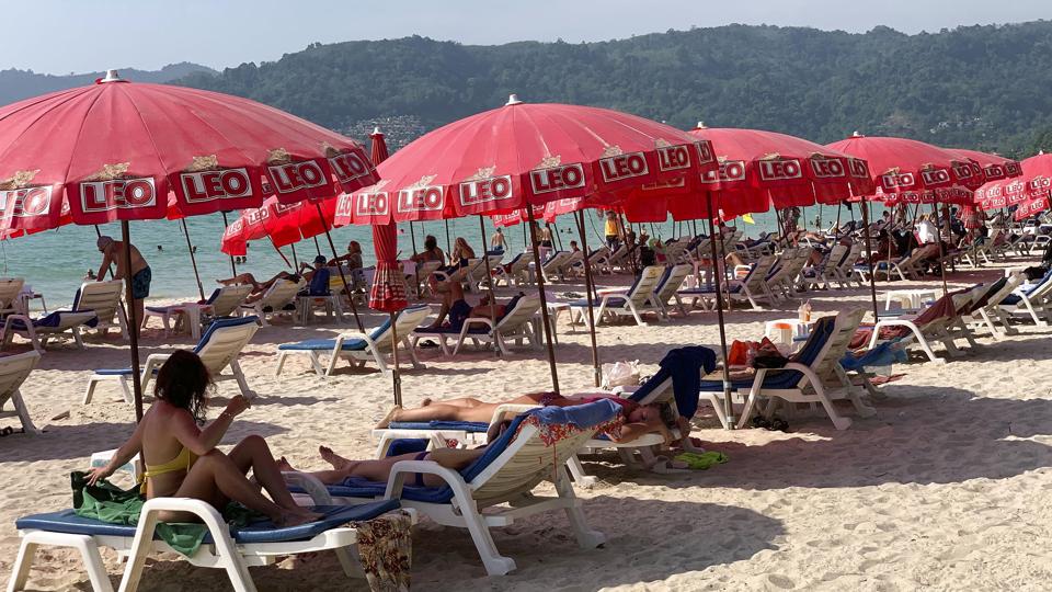 Turister slapper af på Patong Beach i Phuket, Thailand. Billedet er fra fredag den 11. marts. Phuket er et af de steder, hvor der er strandet mange russiske turister på grund af de sanktioner, der er indført mod Rusland i forbindelse med krigen i Ukraine. Deres fly hjem er aflyst, og de har svært ved at hæve penge, fordi russiske banker er under sanktioner.
Friday, March 11, 2022. Thousands of Russian tourists are stranded in Thailand's beach resorts because of the war in Ukraine, many unable to pay their bills or return home because of sanctions and canceled flights. The crisis in Europe also put a crimp in recovery plans for the Southeast Asian nation's tourism industry, which has hosted more visitors from Russia than any of its neighbors before the pandemic hit. (AP Photo/Salinee Prab) <i>Salinee Prab/Ritzau Scanpix</i>