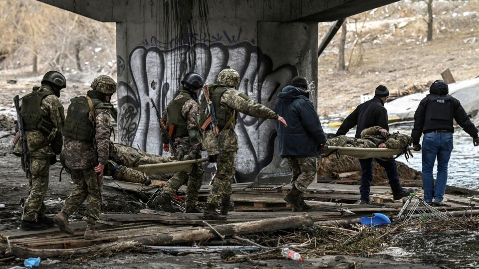 Rusland og Ukraine skal forhandle om invasionen på dens 18. dag. Her ses ukrainske soldater bære kollegers lig. (Arkivfoto). <i>Aris Messinis/Ritzau Scanpix</i>