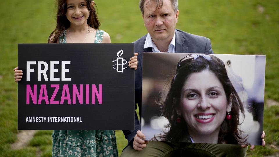 En britisk-iransk kvindelig nødhjælpsarbejder, Nazanin Zaghari-Ratcliffe, der har været fængslet i Iran siden 2016, er blevet frigivet og var onsdag på vej til London. Her ses hendes mand, 
Richard Ratcliffe, og hendes datter, under en tidligere protestaktion overfor Iran. <i>Matt Dunham/Ritzau Scanpix</i>