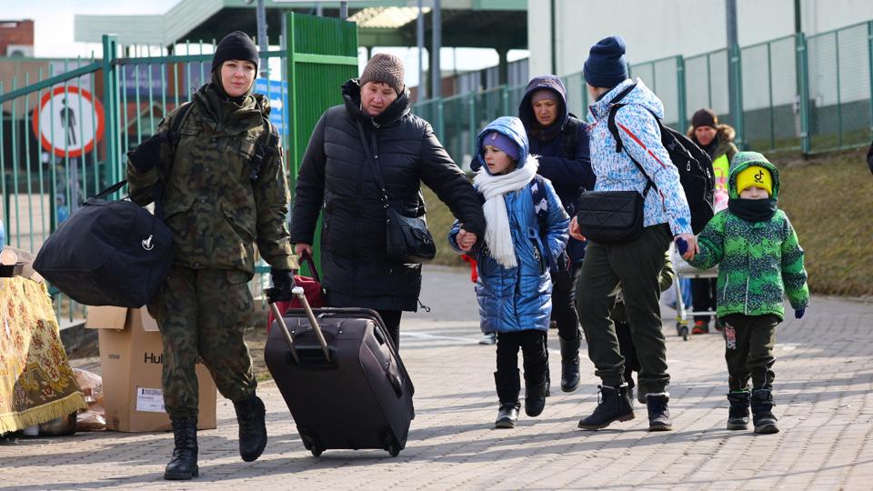 Tusindvis af ukrainere flygter i disse dage ind i Polen. Her hjælper en polsk soldat flygtninge, som er kommet til Medyka i Polen. Lions Club i Hobro og Hjørring sendte en bus til den polsk-ukrainske grænse for at hjælpe flygtninge videre. Nu ankommer de til Nordjylland. Foto: Fabrizio Bensch/Ritzau Scanpix