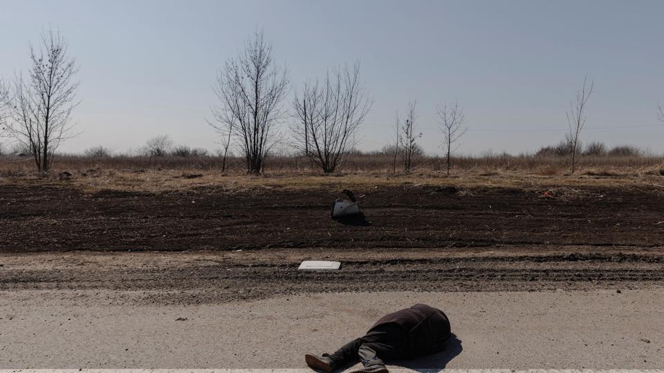Liget af en civil på en vej ved storbyen Kharkiv tirsdag. Den civile blev ifølge ukrainske soldater blev dræbt af russiske soldater. <i>Thomas Peter/Reuters</i>