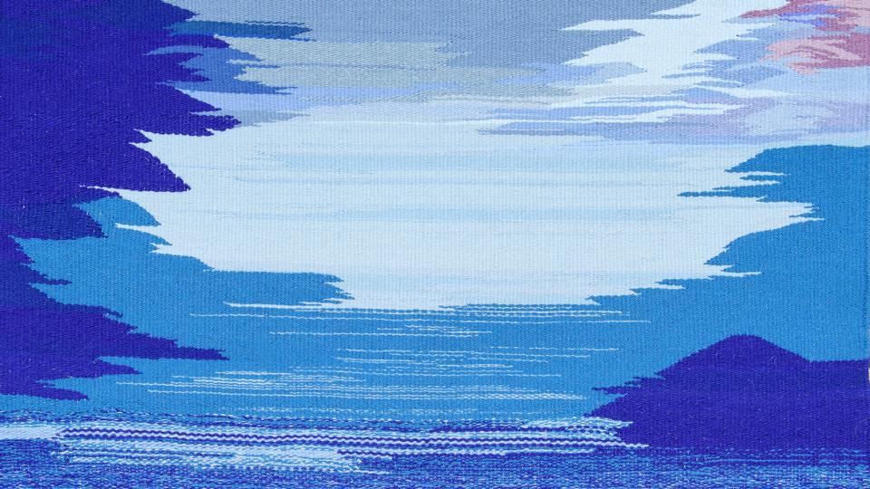 Lone Christensens blå billedtæppe har en ”lys og mystisk kraft, som kan berige livet og lade tålmodigheden få en stemme”, mener kunstneren, der netop nu udstiller i Folkekirkens Hus, Aalborg. Foto: Peter Broen