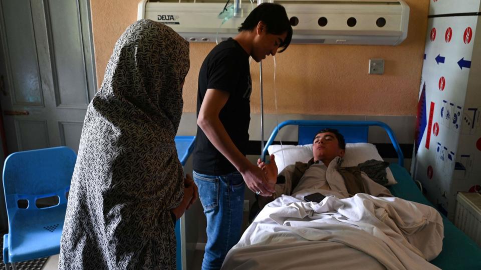 Pårørende på et hospital besøger en såret dreng fra en skole i Kabul, som tirsdag blev rystet af to bombeeksplosioner. <i>Wakil Kohsar/Ritzau Scanpix</i>