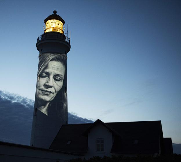 Klaus Holstings portræt af politikeren Marie Krarup projekteret op på et fyrtårn. <i>Pixlart</i>