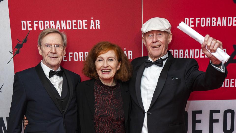 Jesper Christensen (th.) og Bodil Jørgensen er centrum i filmen "De forbandede år 2", der har premiere torsdag. Her ses de med filmens instruktør, Anders Refn, til gallapremiere på den første af hans to film om besættelsen, "De forbandede år", der havde premiere i 2020. <i>Martin Sylvest/Ritzau Scanpix</i>