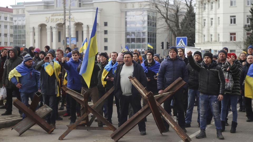 Ukrainere demonstrerede mod russiske soldater i begyndelsen af marts. Byen er i dag besat af russiske styrker, og Rusland indfører flere tiltag for at afstemme byen med russiske forhold. (Arkivfoto). <i>Olexandr Chornyi/Ritzau Scanpix</i>
