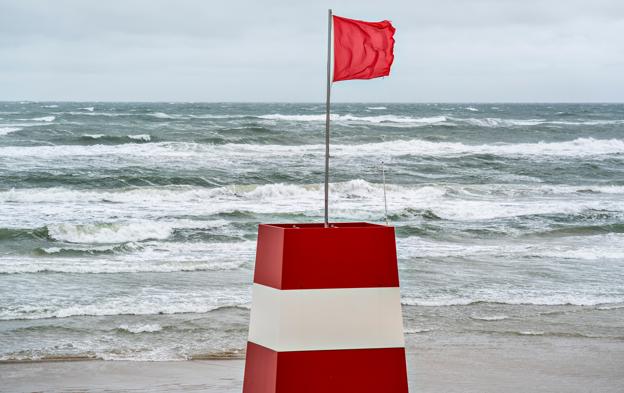 Blæst kan gøre badelivet til en farlig affære, så for egen sikkerheds skyld skal strandgæsterne respektere livreddernes røde flag.  <i>Foto: Henning Bagger/Ritzau Scanpix</i>