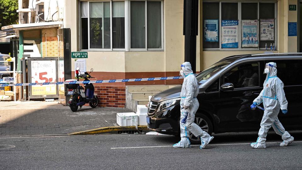 Arbejdere iklædt sikkerhedsdragter fra top til tå i Shanghai transporterede levende mand i ligpose under kaotisk indsats mod corona. (Arkivfoto fra Shanghai) <i>Hector Retamal/Ritzau Scanpix</i>