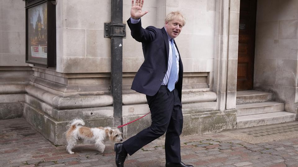 Premierminister Boris Johnson vinker til pressen efter at have stemt ved lokal- og regionalvalg i Storbritannien torsdag. Han havde medbragt sin hund Dilyn. <i>Matt Dunham/Ritzau Scanpix</i>