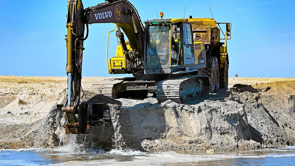 De seneste to år er sandet blev dumpet på stranden nordøst for den lille læmole i Vorupør. Om aftenen skubbes de udlagte dynger i havet. <i>Foto: Ole Iversen</i>