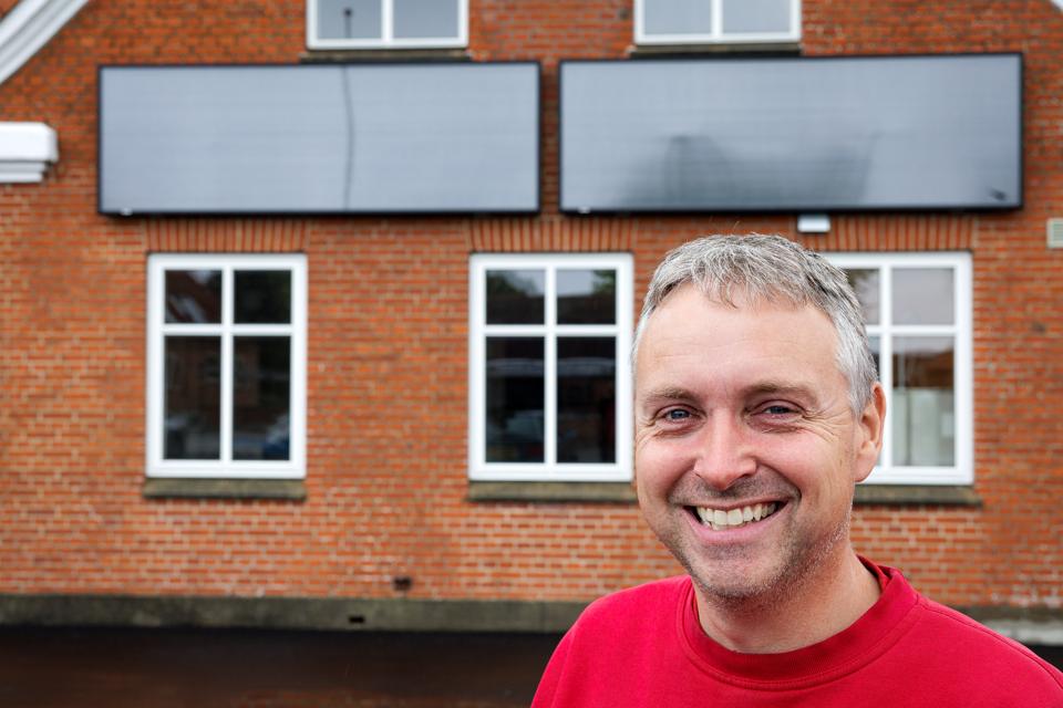 Formand Peter Kibsgaard foran Sundby Mors Forsamlingshus, hvor to solpaneler kan holde huset fugtfrit året rundt. <i>Foto: Bo Lehm</i>