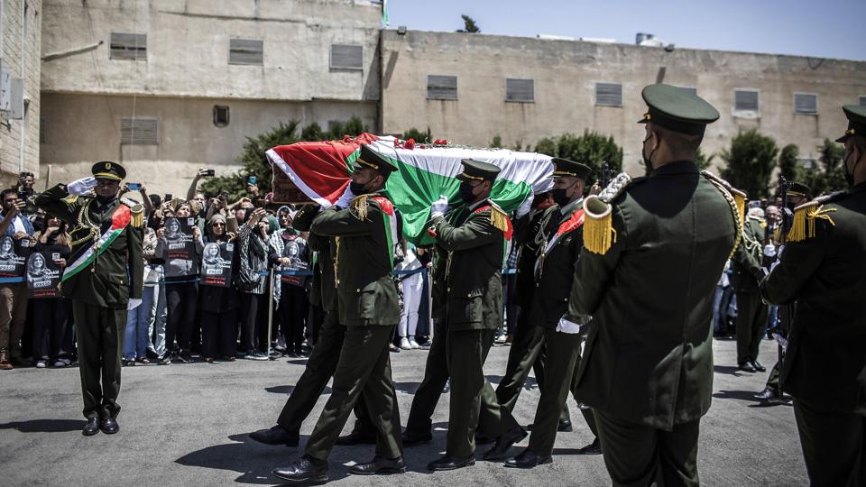 En palæstinensisk æresgarde med veteran-journalisten Shireen Abu Aklehs båre.  Journalisten Shireen Abu Akleh fra den arabiske tv-station al-Jazeera blev begravet i Jerusalem fredag. Tusindvis af mennesker deltog i begravelsesoptoget. <i>Ilia Yefimovich/Ritzau Scanpix</i>