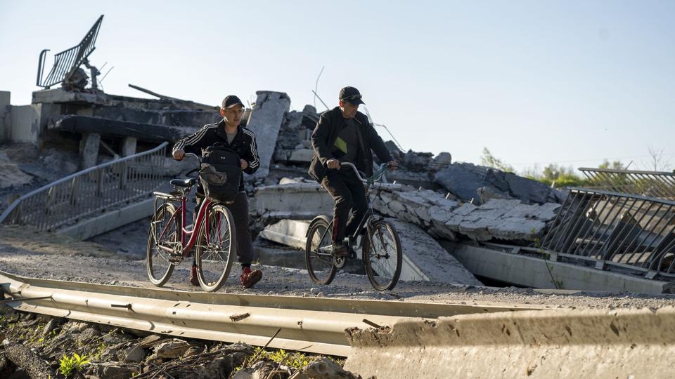 Ødelæggelserne i Ukraine som følge af den russiske invasionen skønnes indtil videre at løbe op i mindst 500  milliarder dollar. Her passerer to cyklister resterne af en bro i Kharkiv-området i den østlige del af landet. <i>Vasiliy Zhlobsky/Ritzau Scanpix</i>