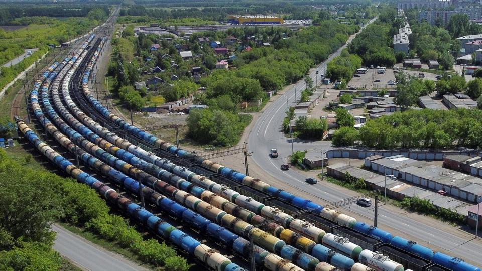 Rusland forventer at få højere indtægter fra salg af olie og gas til udlandet end tidligere beregnet. Det siger den russiske finansminister. En del af pengene skal gå til at finansiere krigen i Ukraine. Luftfoto fra Omsk i Rusland viser et godstog med vogne lastet med olie. <i>Alexey Malgavko/Reuters</i>