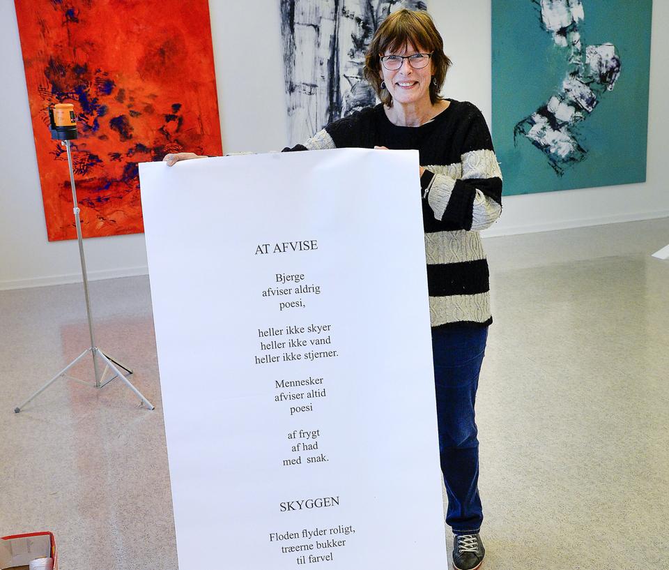 To høje bannere viser på udstillingen digte af japanske Shuntaro Tanikawa, som har inspireret Anita Houvenaeghel til bl.a. billederne på væggen bag hende. Foto: Peter Mørk <i>Foto: Peter Mørk</i>