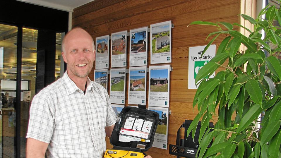 Hans H. T. Sørensen viser den nye hjertestarter som hænger i vindfanget hos Sparekassen Vendsyssels afdeling i Hundelev.Foto: Kirsten Olsen <i>Kirsten Olsen</i>