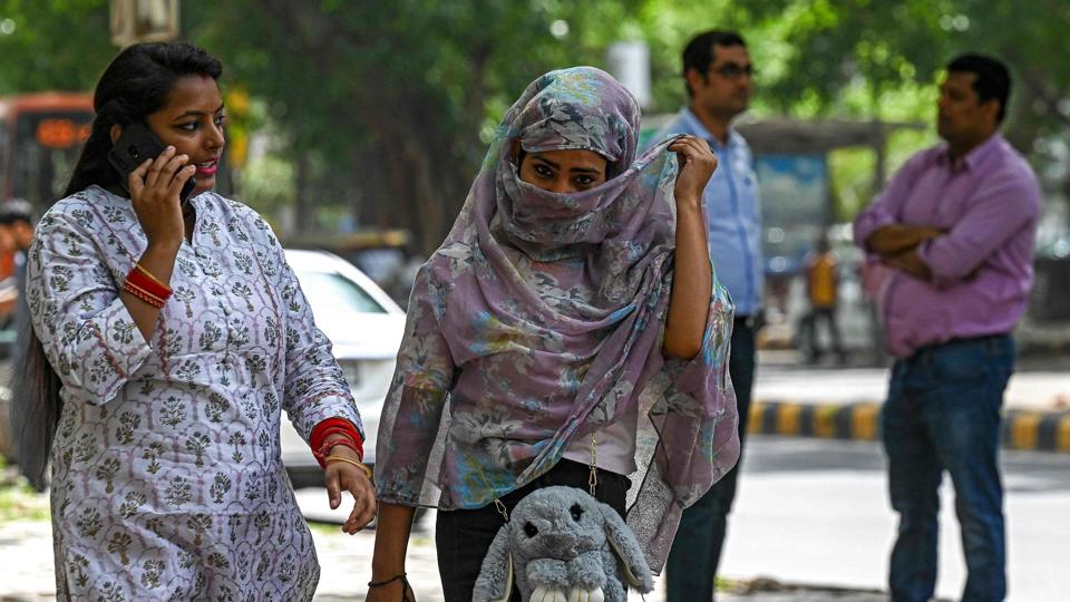 En kvinde dækker sig under sit tøtklæde for at beskytte sig mod solen i New Delhi under en langvarig hedebølge i Indien. Ekstremt vejr i Indien og Pakistan i år giver et glimt af regionens fremtid, siger klimaforskere i et nyt studie. <i>Prakash Singh/Ritzau Scanpix</i>