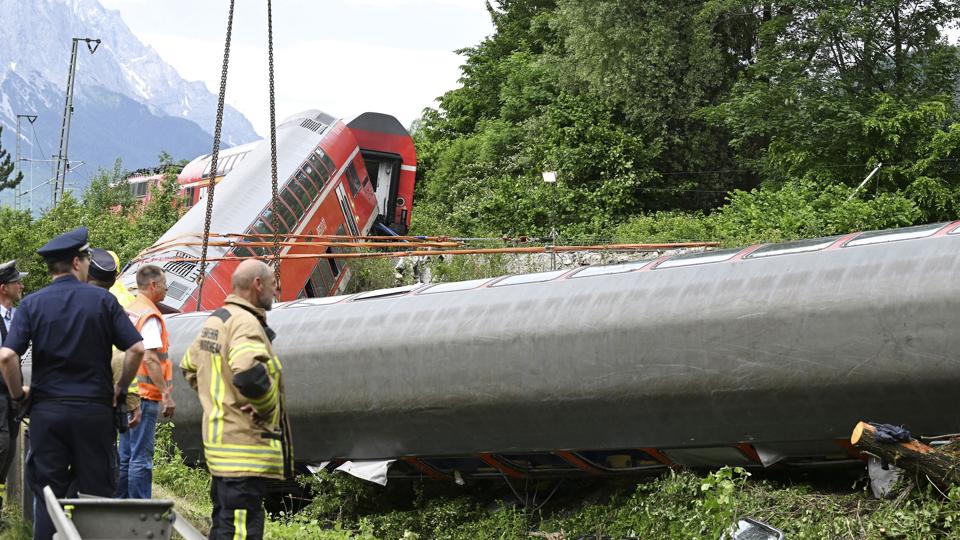 Tysk redningsmandskab arbejder på anden dag ved afsporet tog i Bayern. Myndighederne siger, at ud af de omkring 140 passagerer i toget, der blev afsporet fredag, omkom mindst fire, mens omkring 40 blev kvæstet - heriblandt adskillige børn. <i>Angelika Warmuth/Ritzau Scanpix</i>